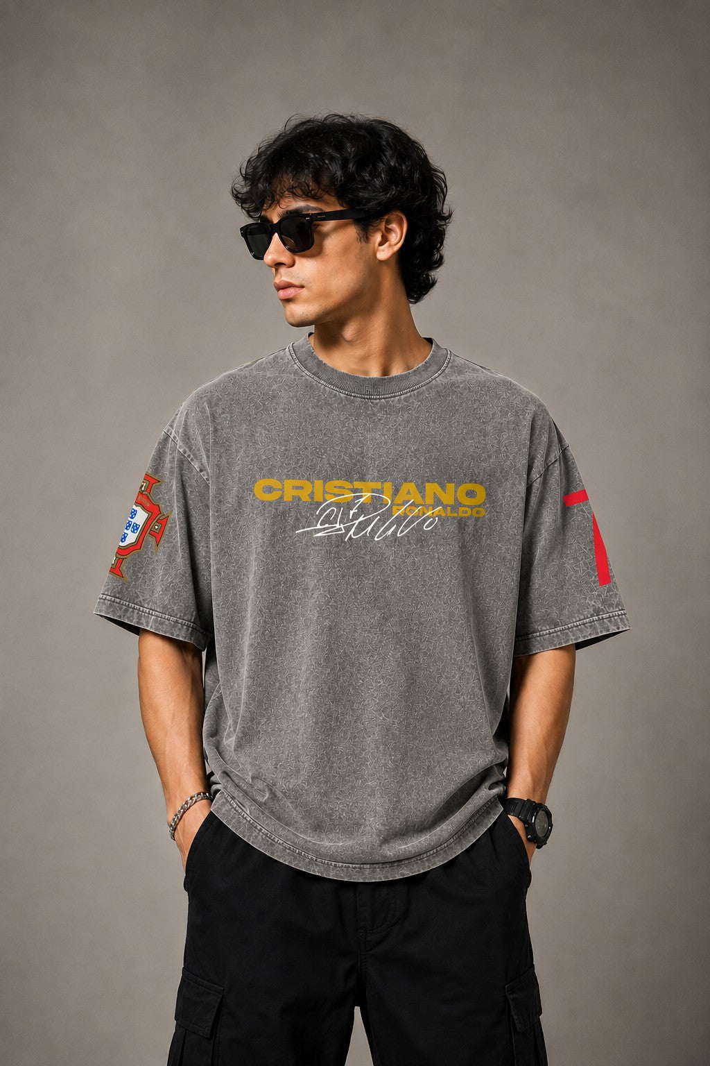 Model wearing a vintage wash dark blue oversized t-shirt with a graphic of Cristiano Ronaldo on the back and "CRISTIANO RONALDO" text on the front. - stone grey