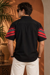 Black Hawaiian shirt with bold red tribal folk art chevron stripe print across chest and sleeves, Cuban collar, men India
