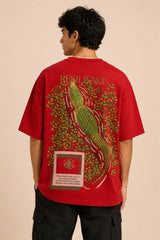 Red oversized t-shirt with "RESILIENCE" embroidered in gold and a green embroidered crocodile graphic. Features a ribbed neckline and premium stitching.