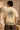 Close-up of a Rooted oversized t-shirt in beige, featuring a dark green circular graphic of a tree of life with tribal figures, and text 'in the rhfym of life'. - beige