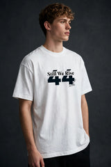 Model wearing white POPCASE Sir Lewis Hamilton oversized t shirt with Still We Rise 44 graphic and signature on chest