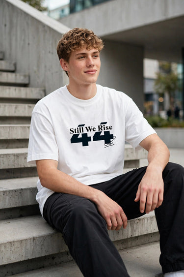 Model wearing white POPCASE Sir Lewis Hamilton oversized t shirt with Still We Rise 44 graphic and signature on chest