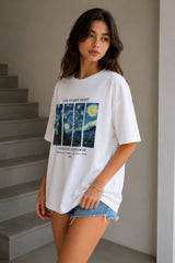 Woman wearing a white t-shirt with a Van Gogh painting design, standing in a neutral indoor setting.