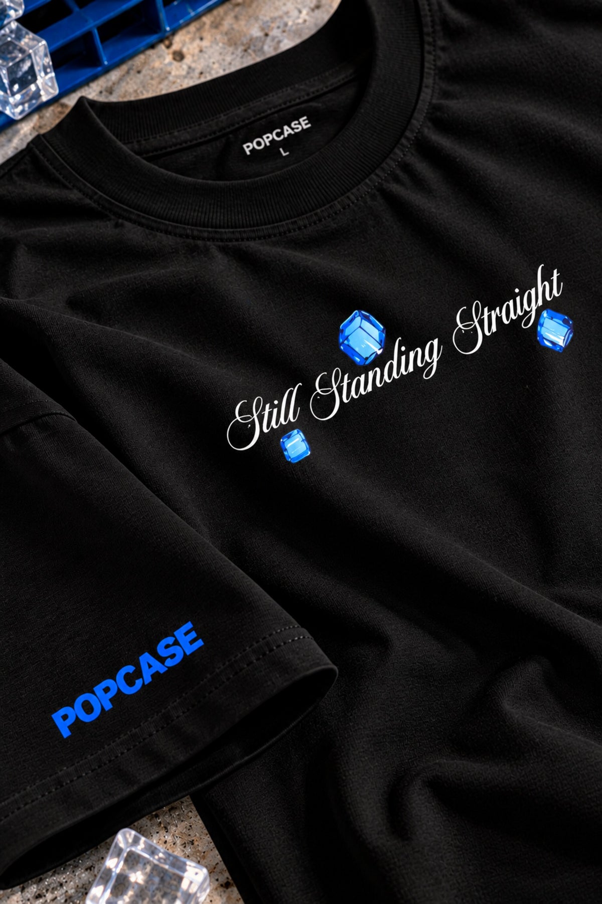 Black oversized tshirt with Still Standing Straight white cursive script and blue accent on chest, drop shoulder boxy fit, men India