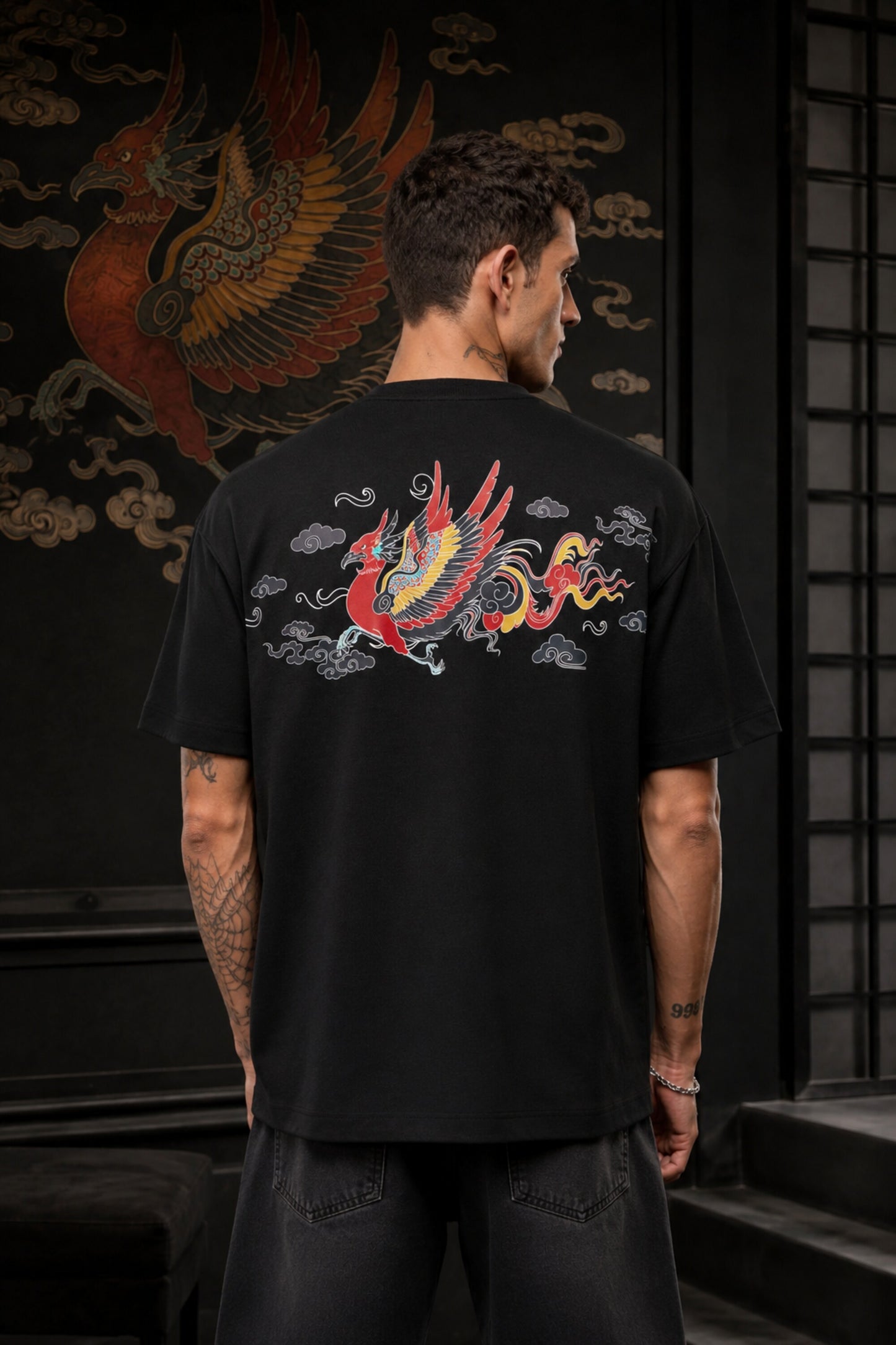 Black oversized t-shirt with Tibetan script in red on golden decorative banner, spiritual streetwear India