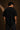 Back view of a man wearing a black UNBREAKABLE TIGER oversized t-shirt, featuring a subtle tonal logo on the upper back. Streetwear aesthetic.
