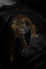 Back view of a man wearing a black UNBREAKABLE TIGER oversized t-shirt, featuring a subtle tonal logo on the upper back. Streetwear aesthetic.