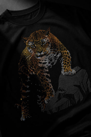 Back view of a man wearing a black UNBREAKABLE TIGER oversized t-shirt, featuring a subtle tonal logo on the upper back. Streetwear aesthetic.