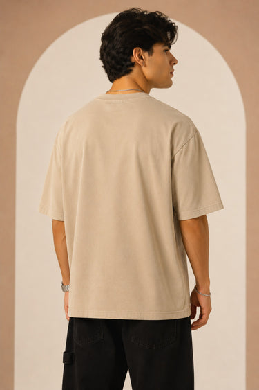 Unbroken Design oversized t-shirt in a beige hue featuring a detailed, stylized brown and green bull graphic print and "UNBROKEN" text across the chest. Showcases ribbed neckline.