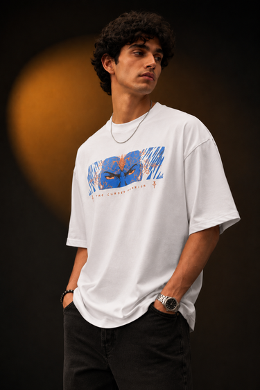 Red oversized t-shirt featuring a bold, blue and orange graphic of Ashwathama's eyes with "The Cursed Warrior" text. Model wearing the t-shirt.