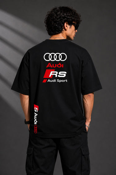 Black oversized Audi RS t-shirt with iconic white and red RS logo on the chest and Audi rings graphic. Premium fabric detail shown.
