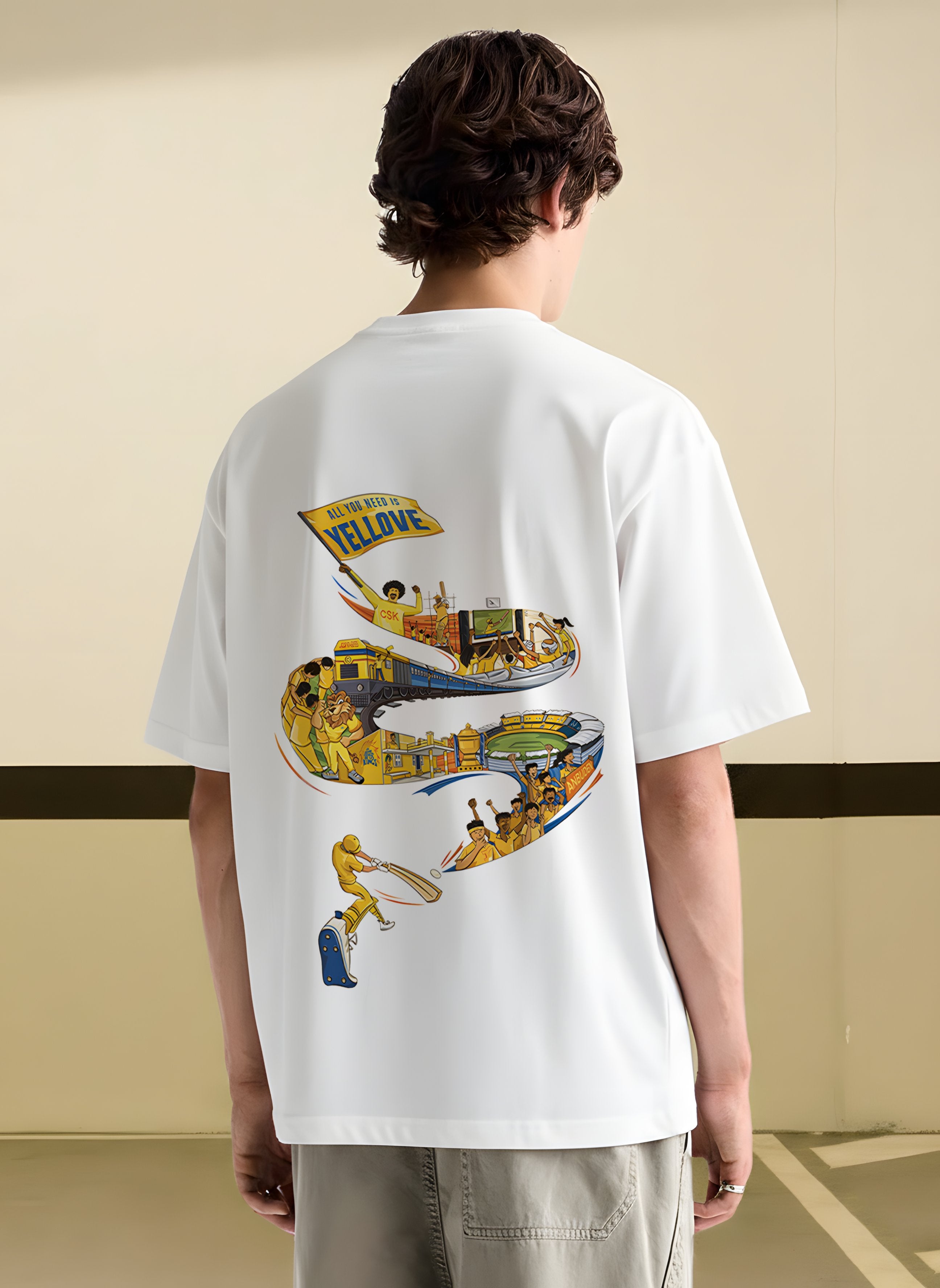 Person wearing a CSK white t-shirt with a colorful snake design on the back against a beige wall.