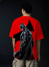 Person wearing a red t-shirt with a Batman graphic on the back against a black background