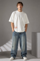 Red oversized t-shirt with 'Drift' graphic print in white and abstract black and yellow brush strokes. Focus on fabric texture and crew neckline.