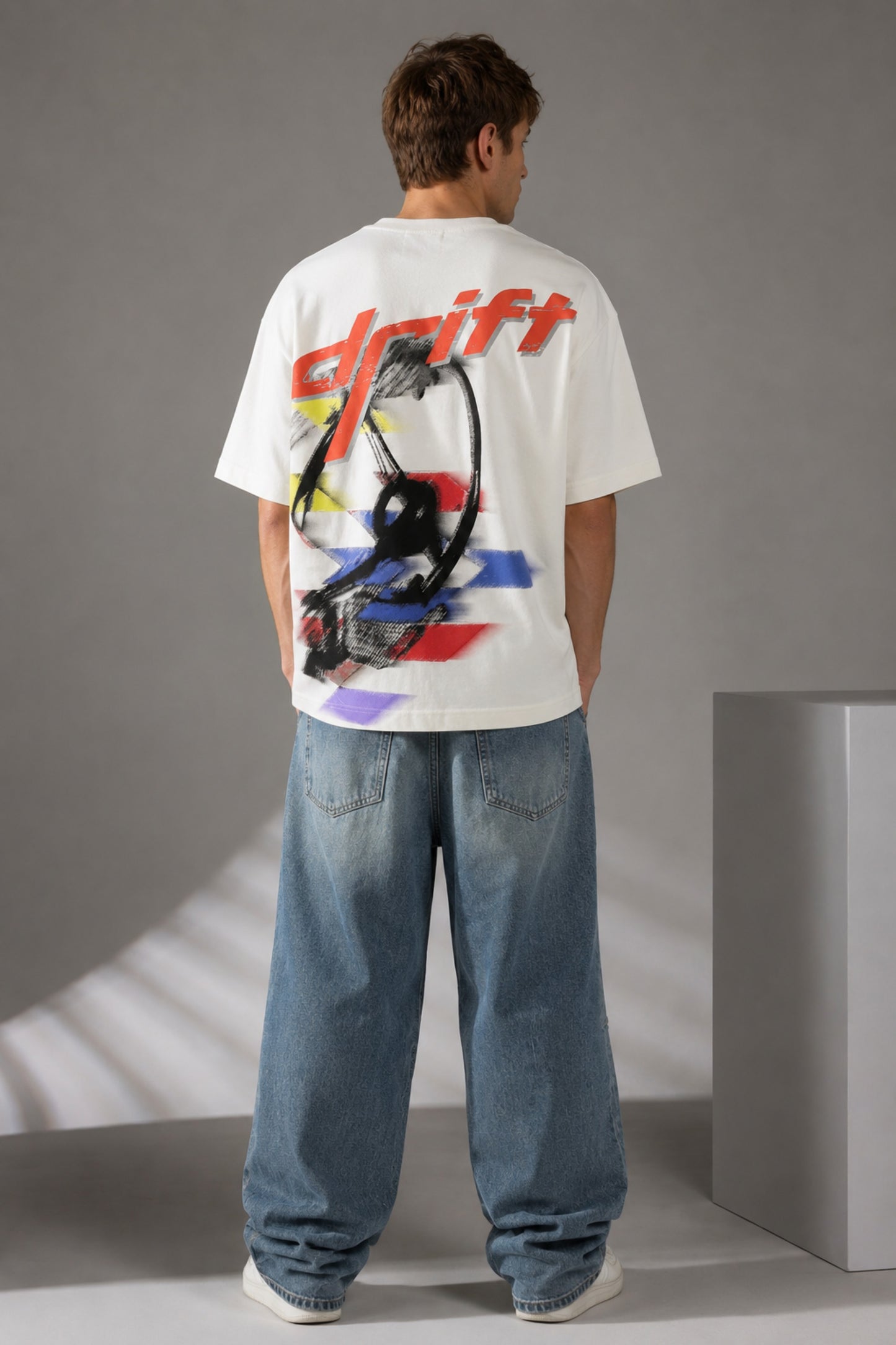 Red oversized t-shirt with 'Drift' graphic print in white and abstract black and yellow brush strokes. Focus on fabric texture and crew neckline. - white