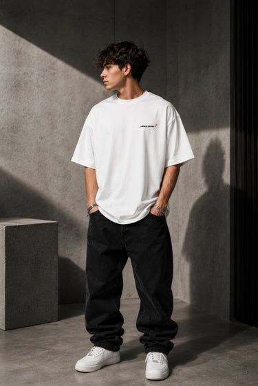 McLaren Formula 1 '2025 MCL39' design on a white oversized t-shirt, featuring a graphic of the F1 car on a checkered flag. Showcasing premium cotton fabric.