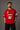 Close-up of a red Ferrari oversized t-shirt featuring the iconic yellow prancing horse logo and 'Ferrari 93' graphic. The fabric has a premium, textured look, showcasing high-quality print and material.