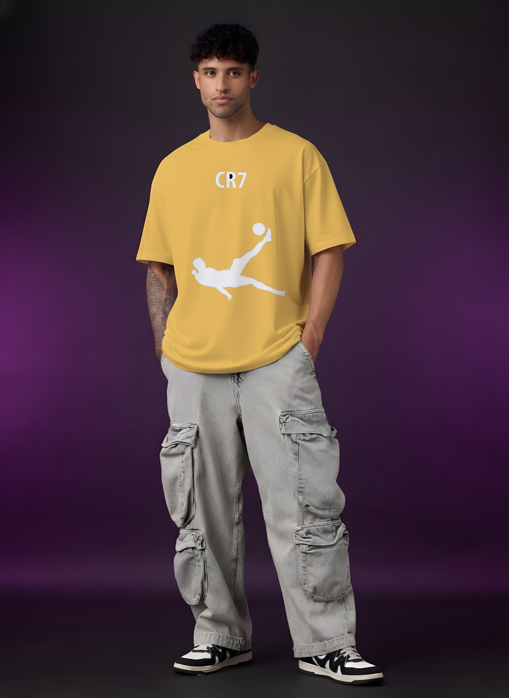 Person wearing a yellow t-shirt with a graphic design on a purple background