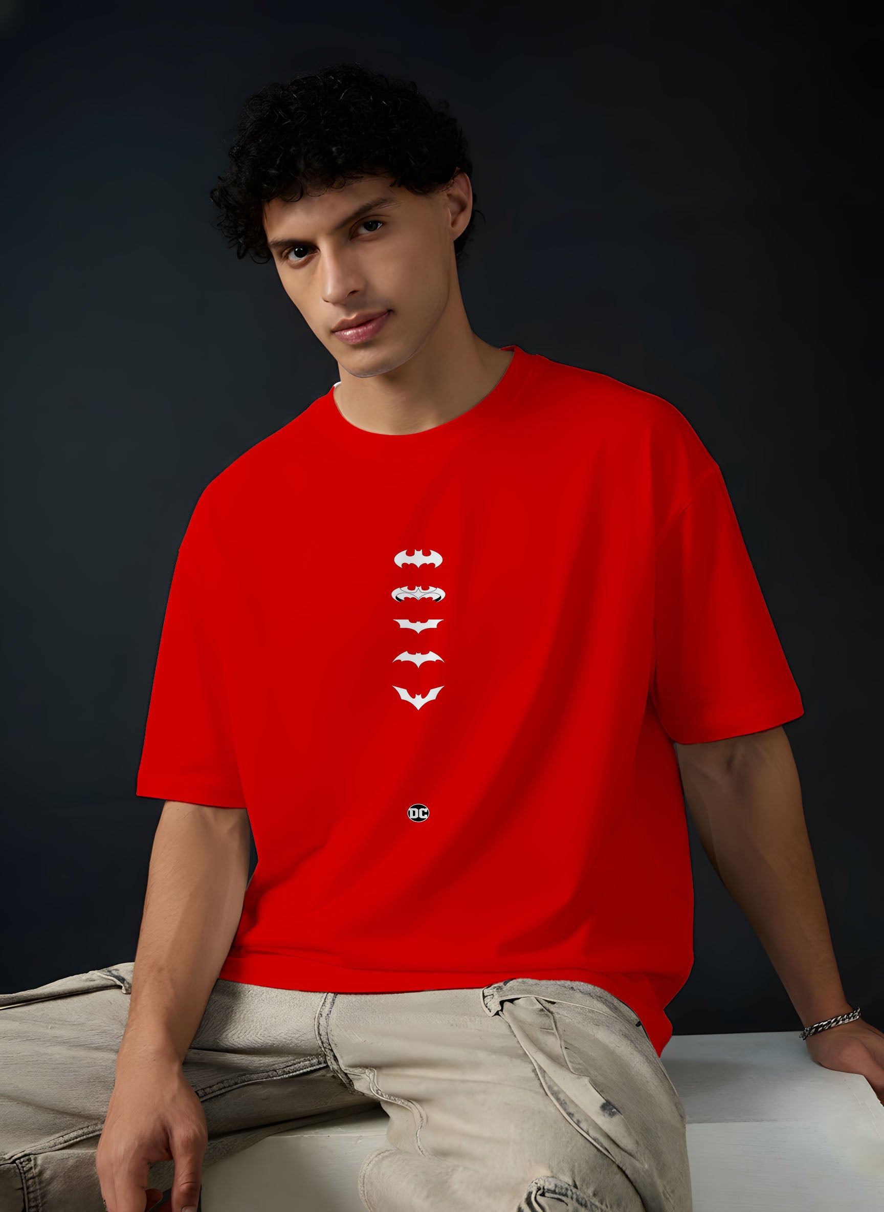 Person wearing a red t-shirt with white graphic design on a dark background