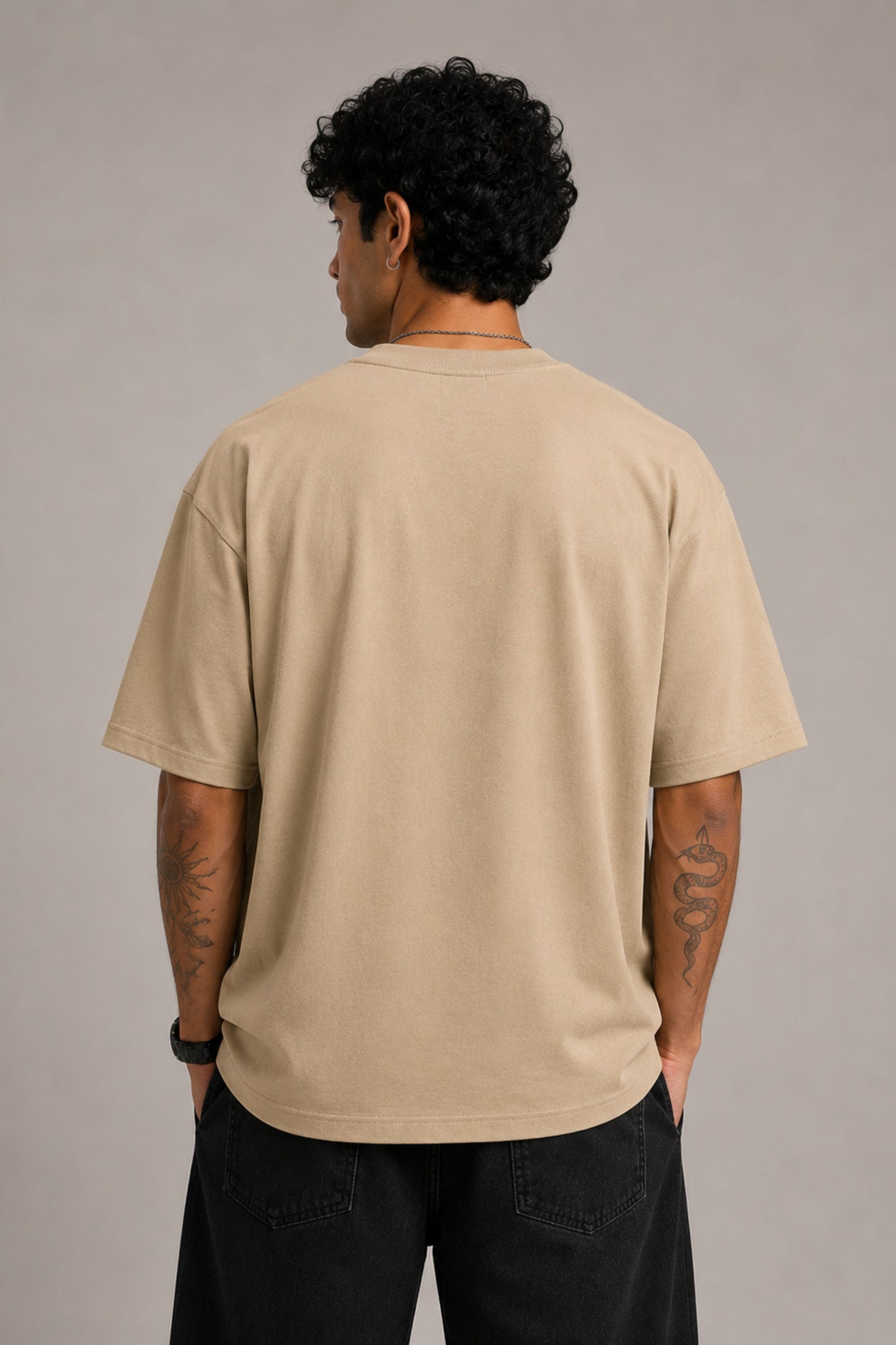 Beige oversized t-shirt with "Hogwarts is Home" text and a detailed sketch of Hogwarts castle. Premium cotton fabric visible.