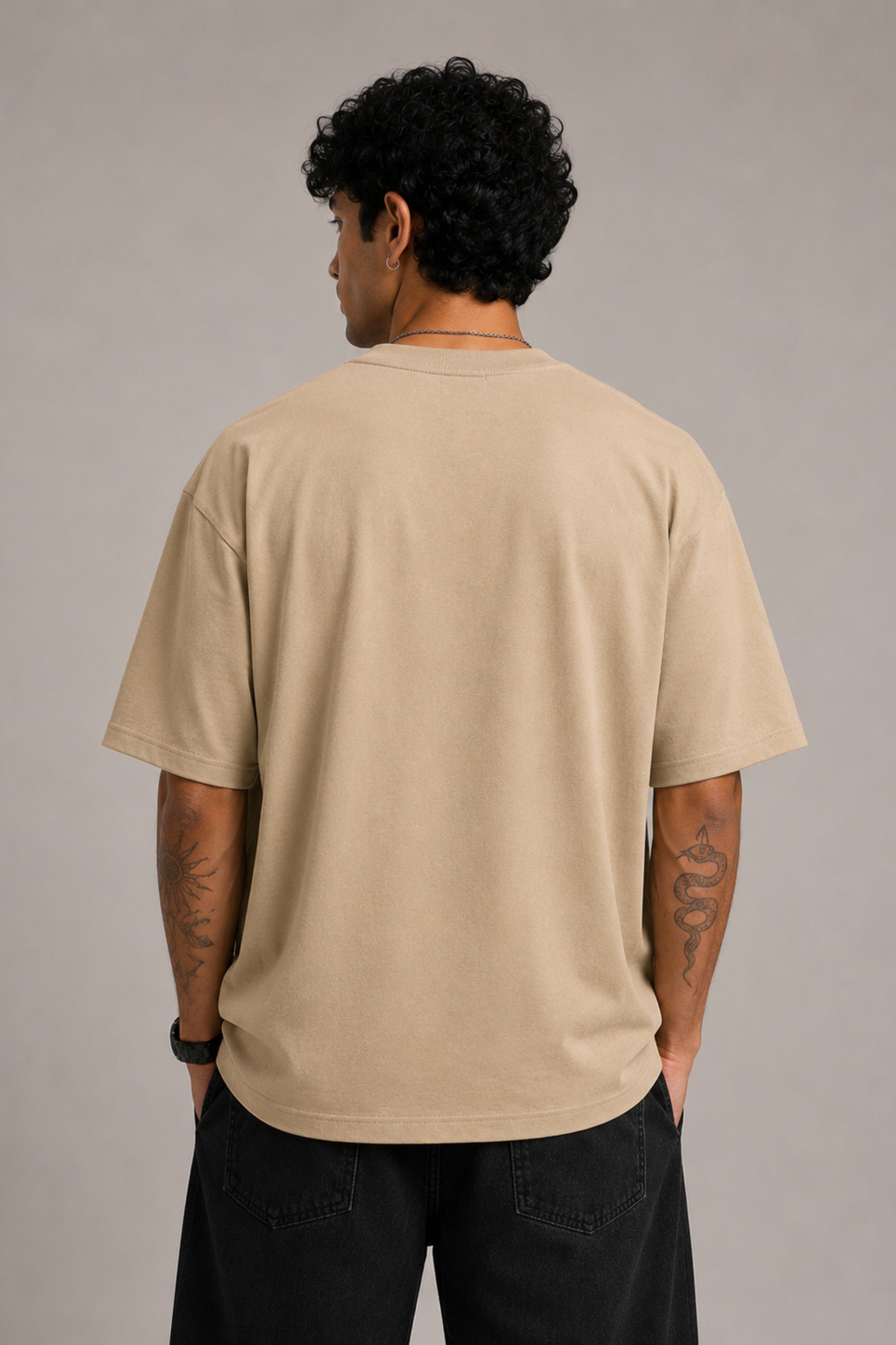 Beige oversized t-shirt with "Hogwarts is Home" text and a detailed sketch of Hogwarts castle. Premium cotton fabric visible.