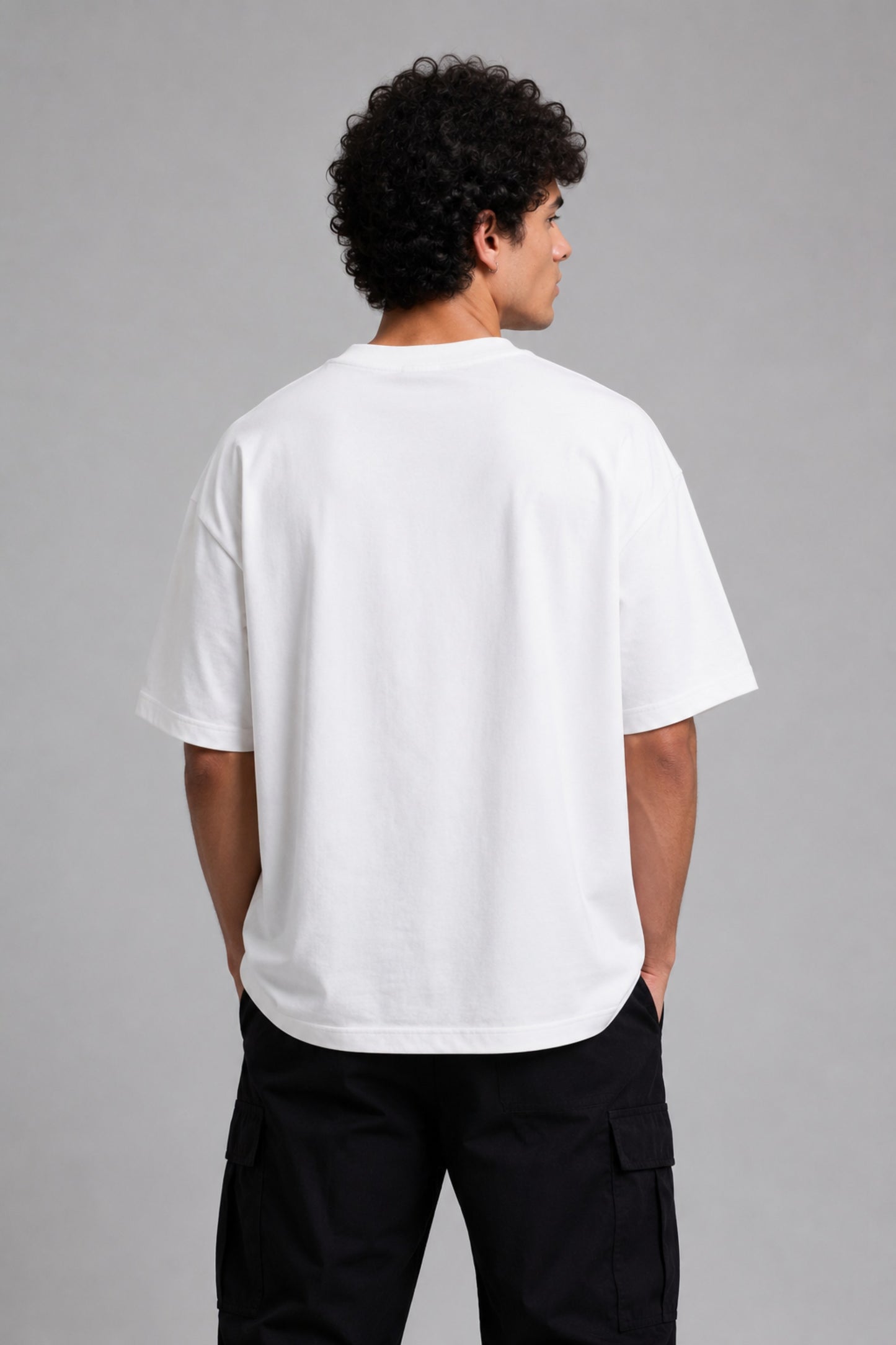 Man wearing a black kuwansugg DESIGN oversized t-shirt with a white graphic print of a knight on a horse. The t-shirt is made of premium cotton.