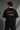 Black Mercedes-Benz and AMG oversized t-shirt with red stripe detail. Features the iconic Mercedes-Benz star logo and AMG lettering. Styled for a premium streetwear look.