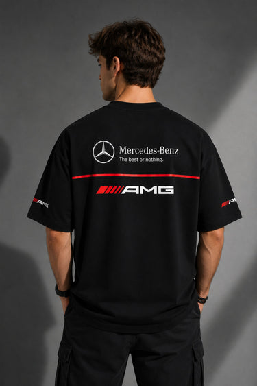 Black Mercedes-Benz and AMG oversized t-shirt with red stripe detail. Features the iconic Mercedes-Benz star logo and AMG lettering. Styled for a premium streetwear look.