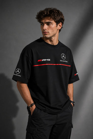 Black Mercedes-Benz and AMG oversized t-shirt with red stripe detail. Features the iconic Mercedes-Benz star logo and AMG lettering. Styled for a premium streetwear look.