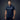 Man wearing a navy blue polo shirt with a logo on a dark background
