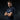 Man wearing a navy blue polo shirt with a logo on a dark background