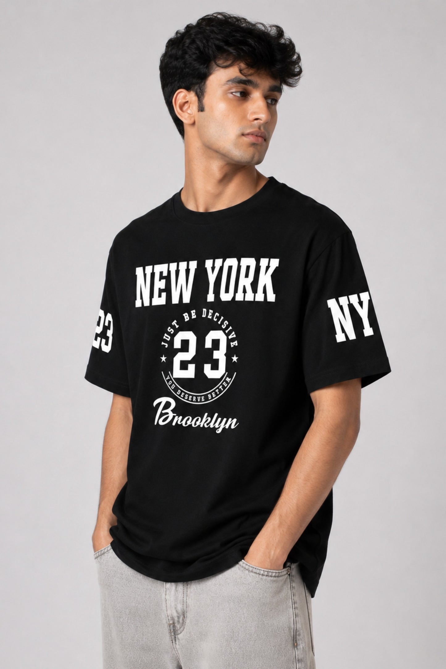 Man wearing a black t-shirt with 'New York 23' and 'Brooklyn' text on a gray background