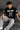 Person wearing a black t-shirt with 'New York 23 Brooklyn' text, sitting on steps.