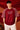 Dark red POPCASE 'Unstoppable' oversized t-shirt with white raised print, featuring ethnic patterned sleeves. Close-up shot showcasing fabric texture and print detail.