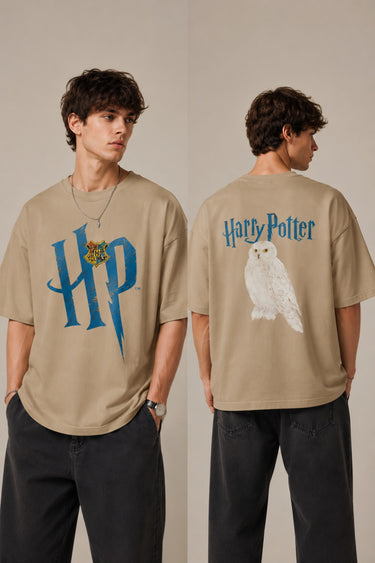 Model wearing a black Harry Potter Gryffindor oversized t-shirt with a blue 'HP' graphic and Hogwarts crest. Features black sunglasses, silver necklace, and dark pants. - beige