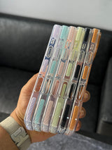 Set of clear phone cases with colorful accents held in a hand.