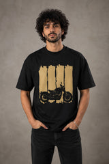 Back view of a man wearing an ENFIELD DESIGN black oversized t-shirt against a textured grey background. Features relaxed fit and premium cotton. - black