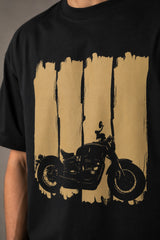 Back view of a man wearing an ENFIELD DESIGN black oversized t-shirt against a textured grey background. Features relaxed fit and premium cotton. - 4