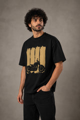 Back view of a man wearing an ENFIELD DESIGN black oversized t-shirt against a textured grey background. Features relaxed fit and premium cotton. - 7