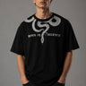 Beige oversized t-shirt with a detailed vintage-style grey snake graphic and 'MOVE IN SILENCE' text. The fabric is soft-washed premium cotton.