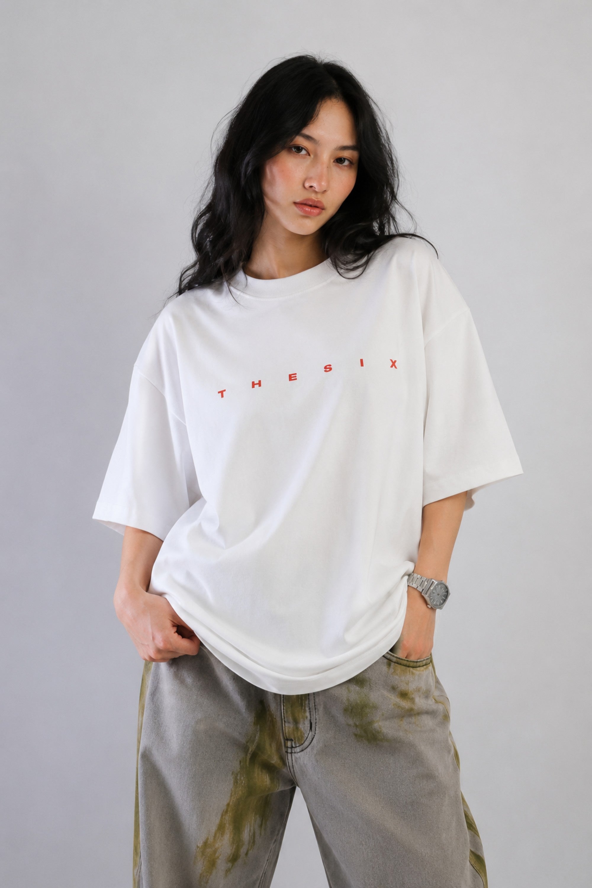 White oversized t-shirt from The Six Design featuring a bold red and blue graphic print of the numbers 3, 6, and 9. The t-shirt has a relaxed fit and is made of premium cotton.