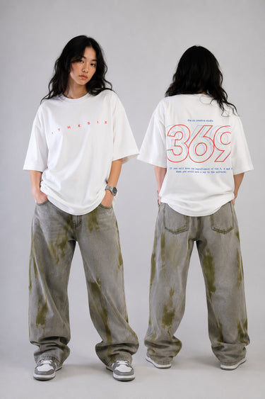 White oversized t-shirt from The Six Design featuring a bold red and blue graphic print of the numbers 3, 6, and 9. The t-shirt has a relaxed fit and is made of premium cotton.