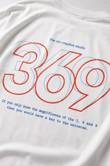 White oversized t-shirt from The Six Design featuring a bold red and blue graphic print of the numbers 3, 6, and 9. The t-shirt has a relaxed fit and is made of premium cotton.