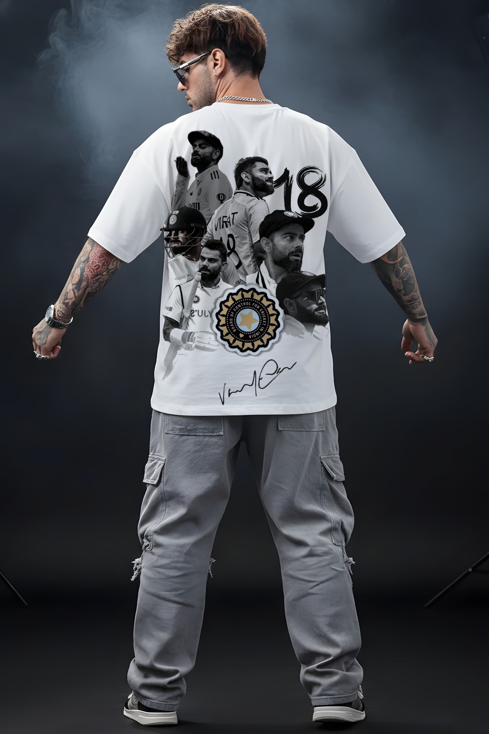 Person wearing a white Virat t-shirt with graphic designs and text, standing against a dark background.