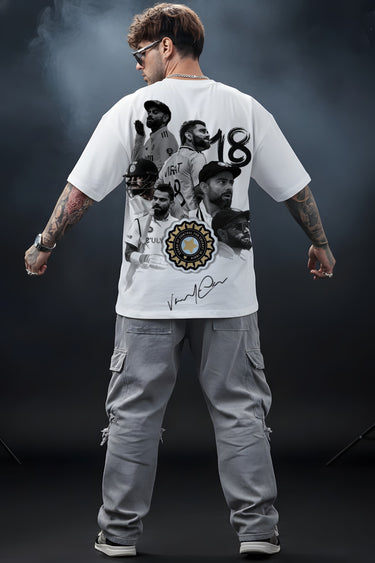 Person wearing a white Virat t-shirt with graphic designs and text, standing against a dark background.